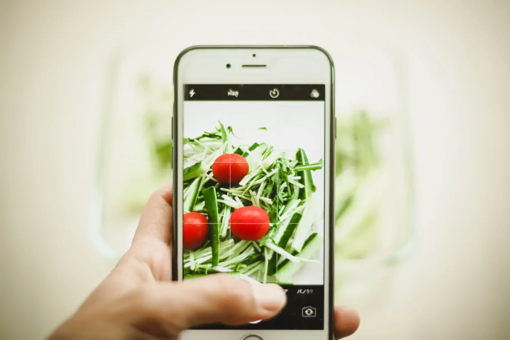 スマートフォンで料理を撮影している画像